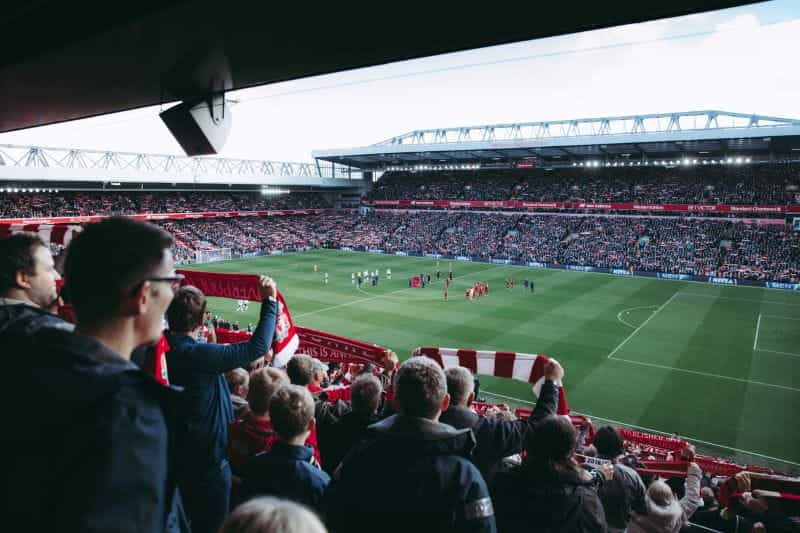 A crowd of football fans watching a match in a stadium.