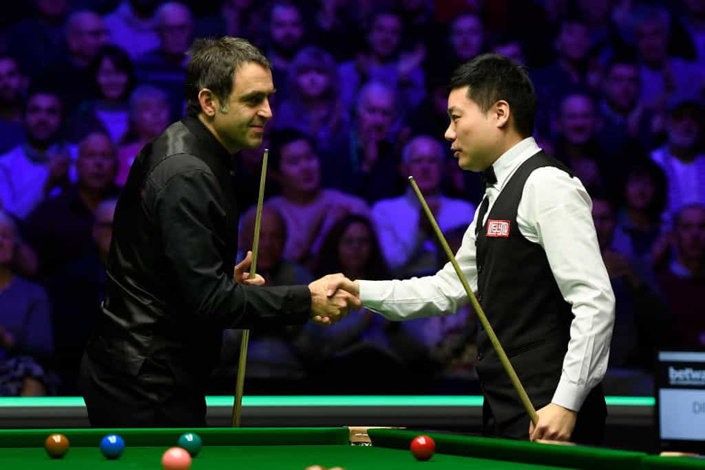 Ronnie O’Sullivan and Ding Junhui shake hands at the conclusion of a 2021 match. 