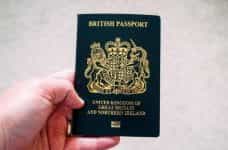 Hand holding a British passport.