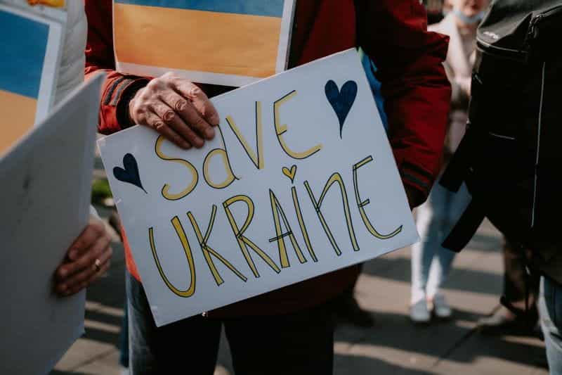 A handwritten sign saying Save Ukraine with a heart on it.