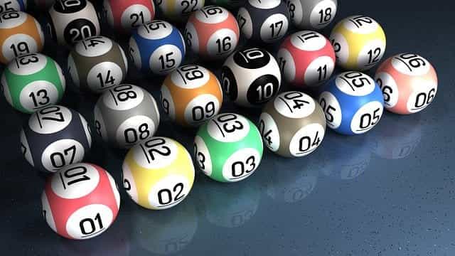 Colored lottery balls with numbers on lined up.