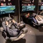 Two racing car simulators with drivers in arcade setting.