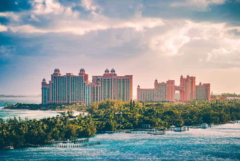 The Atlantis Paradise Island casino-resort towers against a dramatic, cloudy sky at sunset.