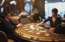 A casino table with a dealer and a player.
