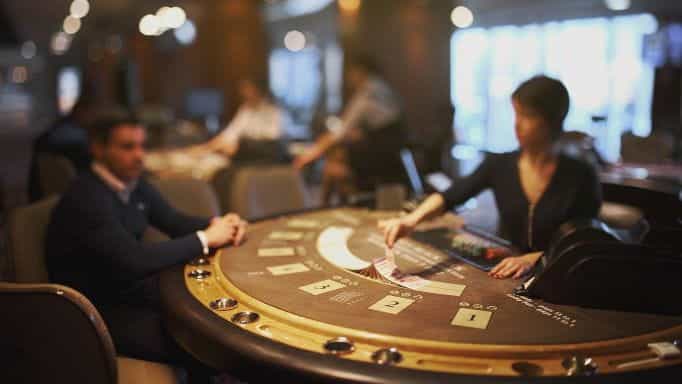A casino table with a dealer and a player.