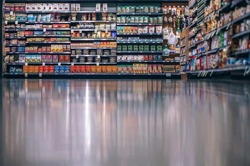 The stocked shelves of an aisle in a grocery store, featuring a wide assortment of different products.