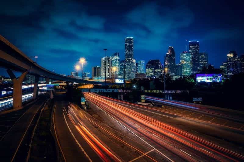 The highway leading to downtown Houston, Texas at night, with the city’s skyline seen to the right in the near distance.