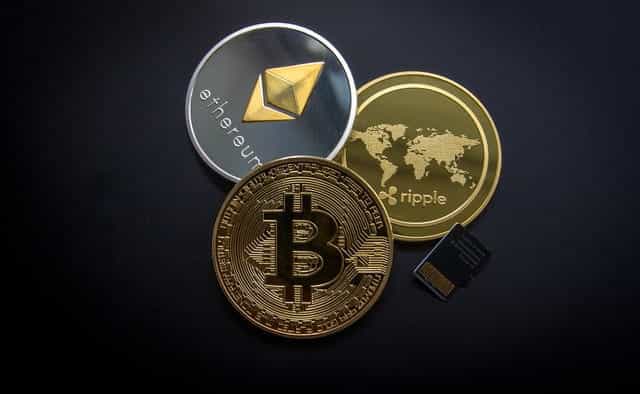Bitcoin, Ethereum and Ripple cryptocurrency coins.