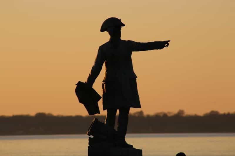 A statue of a colonial era fisherman pointing out at sea in the town of Newport, Rhode Island in the United States.