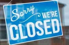 A blue shop sign that says sorry we're closed.