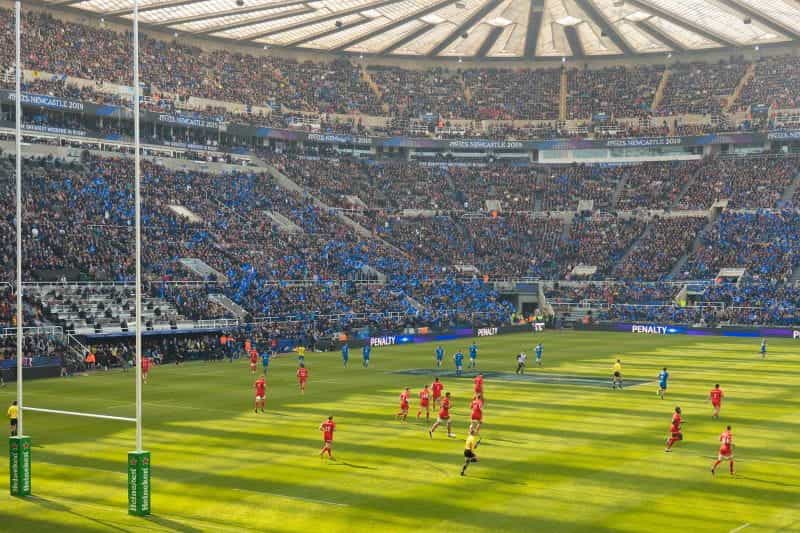A rugby match being played in a stadium with fans watching.