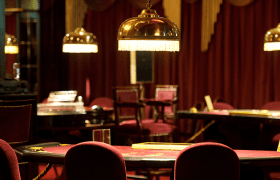 The interior of a casino featuring several games tables.