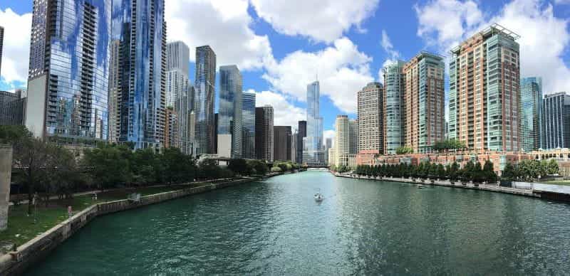 Downtown Chicago over a wide river, with towering skyscrapers on either side of the body of water.
