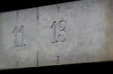 The number 13 is engraved in a concrete, while other numbers around it are blurred.
