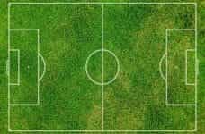 An overhead view of a football pitch markings in white on grass.