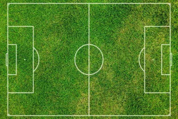 An overhead view of a football pitch markings in white on grass.