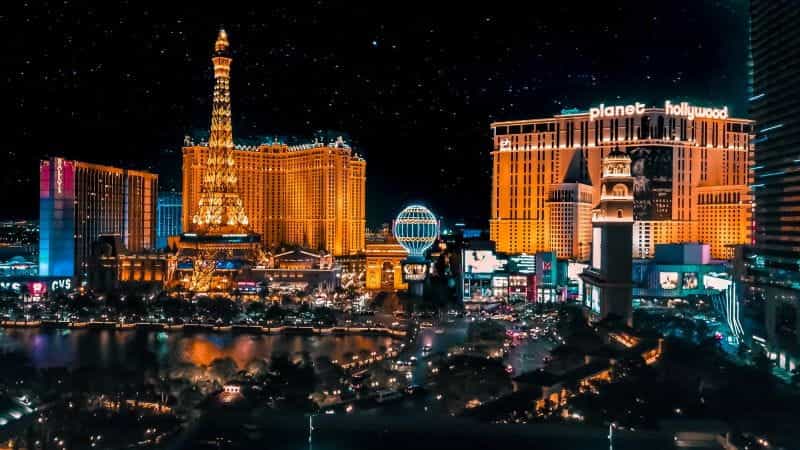 Las Vegas hotels and Eiffel Tower lit up at night.
