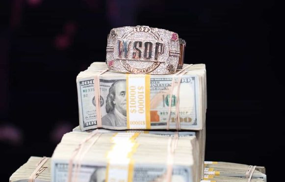 A World Series of Poker bracelet sits on a huge pile of cash.