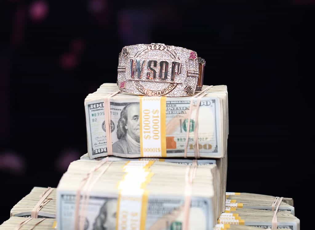 A World Series of Poker bracelet sits on a huge pile of cash.