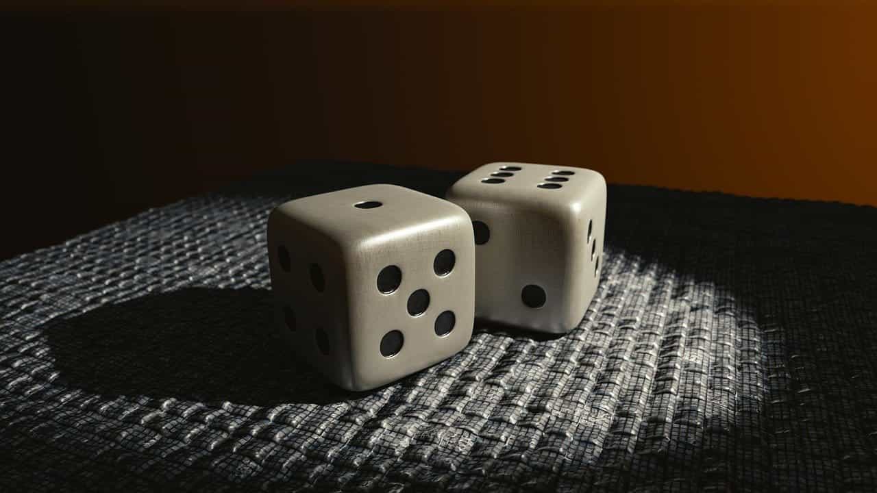 Two die resting on a corrugated surface with a spotlight shining on them.