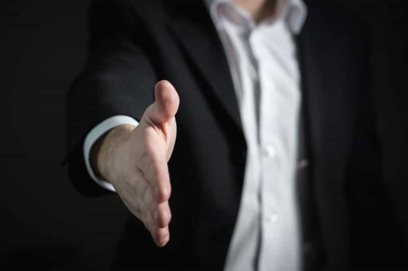 A businessman holds out his hand.