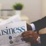 A businessman reads the business pages of a newspaper.