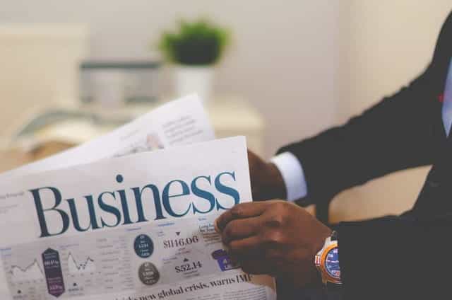 A businessman reads the business pages of a newspaper.