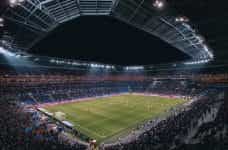 A full soccer stadium at night in Lyonnais.