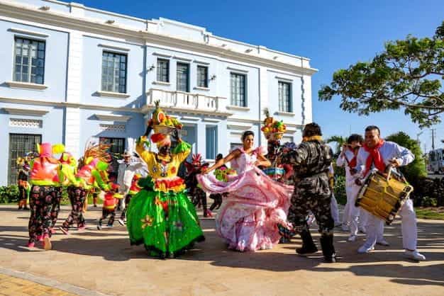 Orang-orang dengan pakaian berwarna-warni menari selama perayaan di Kolombia.
