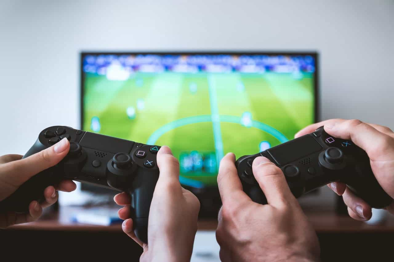 Dua orang bermain video game sepak bola.