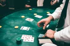 A croupier dealing cards in a game of poker at a casino.