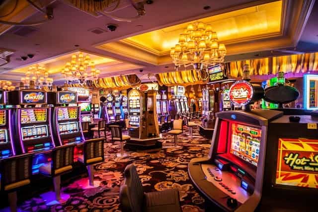 A casino floor covered in colorful, brightly lit slot machines.