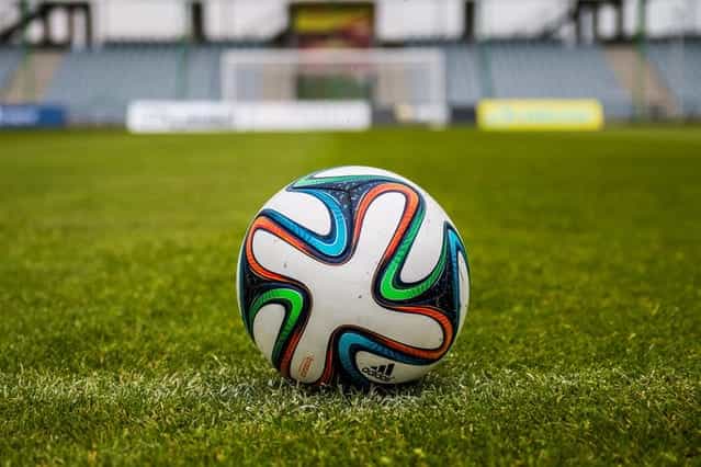 A football on a grass pitch.
