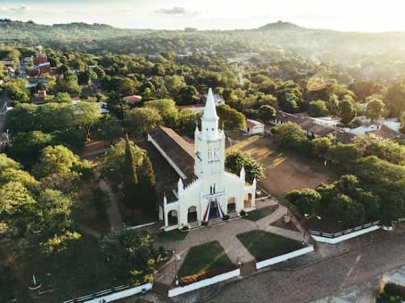 Sebuah bangunan gereja yang dikelilingi oleh pepohonan hijau di Paraguay.