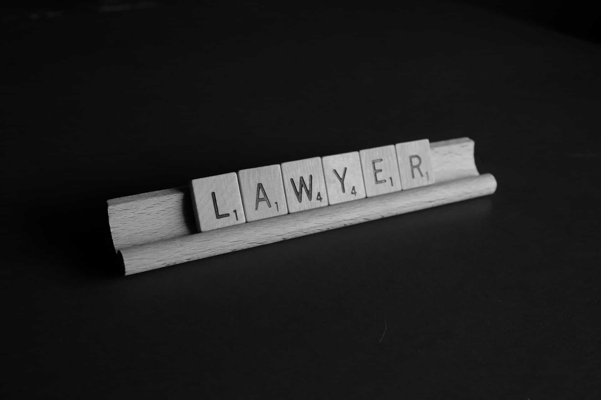 Scrabble tiles spell out the word LAWYER.