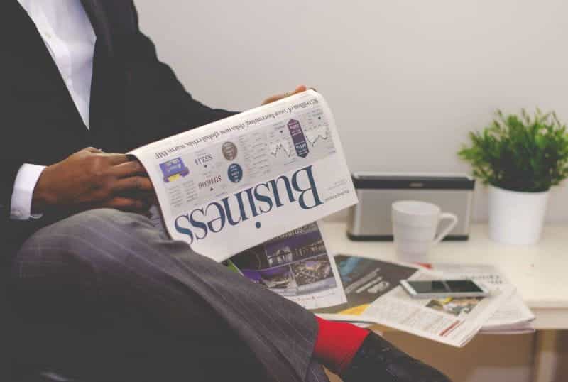 A businessman in a suit reading a newspaper.