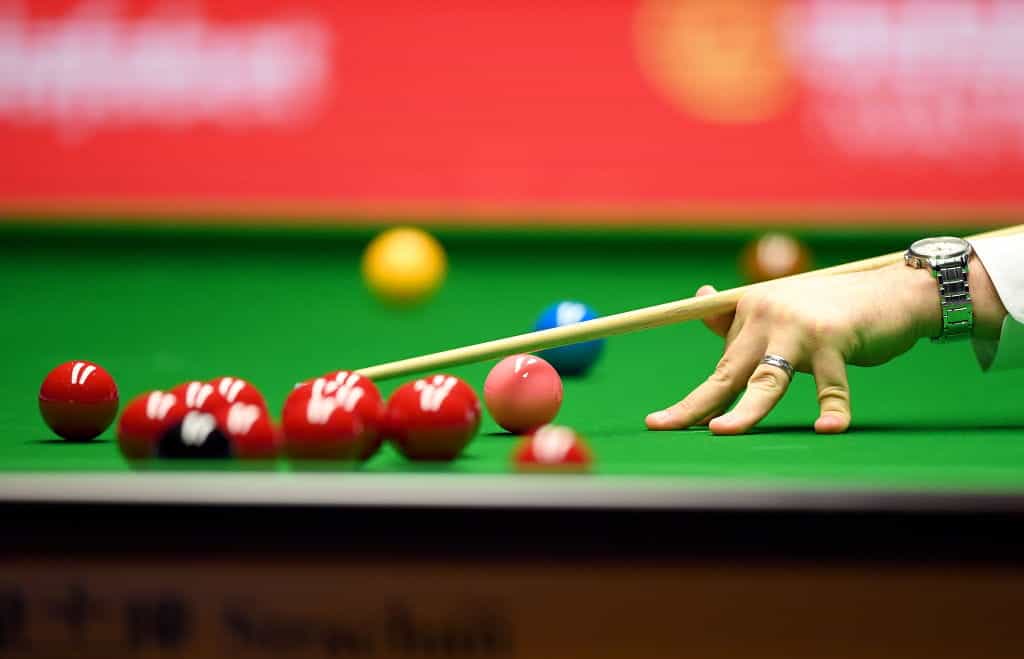 A detailed view of a cue and snooker balls.