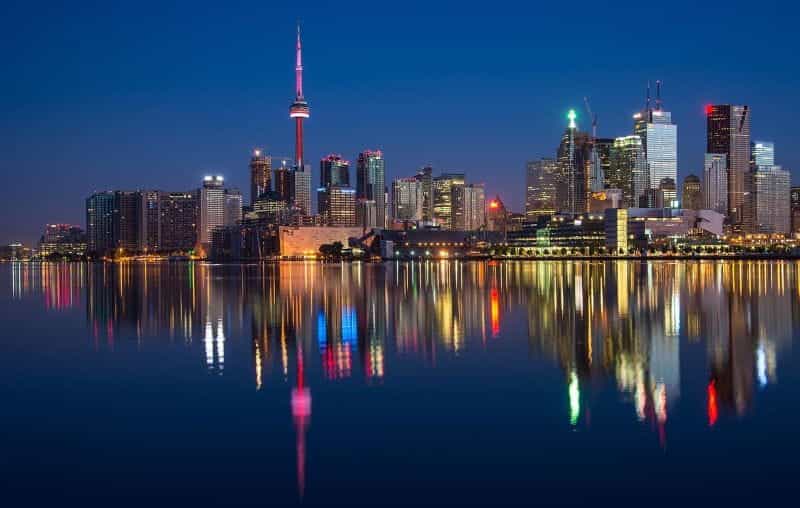 Cakrawala Toronto di malam hari dari Danau Ontario, dengan Menara CN yang ikonik terlihat jelas.