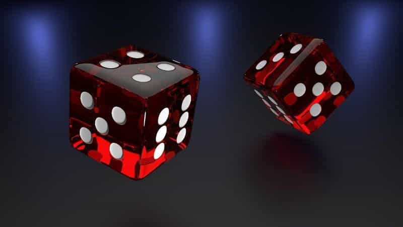 Two dark red dice in the air before they land.