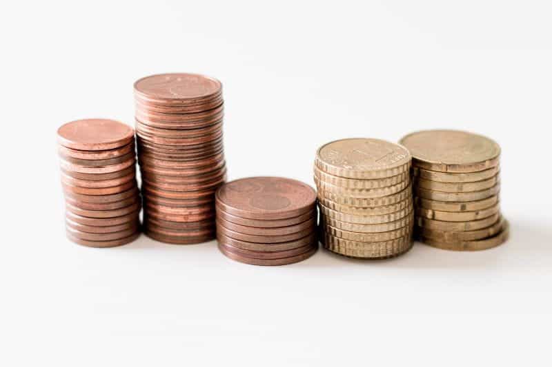 Stacks of coins sit on a white background.