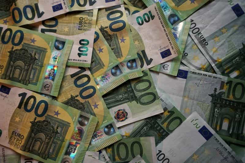 Uang kertas 100 euro tersebar di permukaan yang datar.