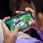 A man playing a video game on his mobile phone.