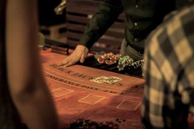 A casino dealer dealing a game of Blackjack.