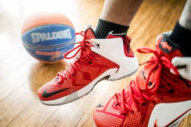 Kaki pemain basket dengan sepatu basket merah.