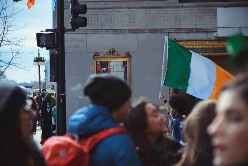 A man holding an Irish flag in a crowd.
