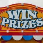 A hand-painted carnival sign reads WIN PRIZES.