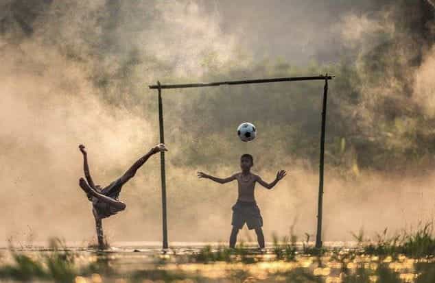 Anak-anak bermain sepak bola di Asia.