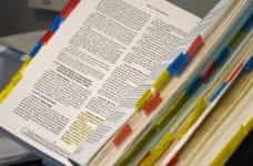 An open hardbound book with colorful annotations along the edges.