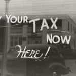 A window is painted to say PAY YOUR TAX NOW HERE!