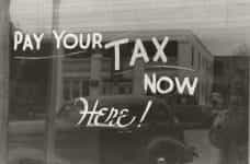 A window is painted to say PAY YOUR TAX NOW HERE!